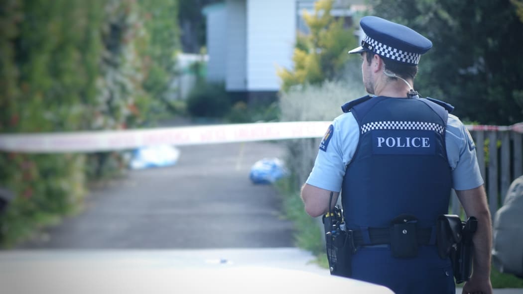A police officer near the Te Atatu house where Cun Xiu Tian, 69, was found dead.