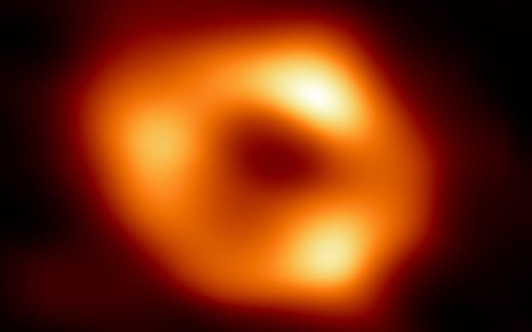 This handout image released by the European Southern Observatory (ESO) on May 12, 2022, shows the first image of Sagittarius A*, the supermassive black hole at the centre of our own Milky Way galaxy. - An international team of astronomers on May 12, 2022, unveiled the first image of a supermassive black hole -- a cosmic body known as Sagittarius A*. The image, produced by a global team of scientists known as the Event Horizon Telescope (EHT) Collaboration, is the first, direct visual confirmation of the presence of this invisible object, and comes three years after the very first image of a black hole from a distant galaxy. Black holes are regions of space where the pull of gravity is so intense that nothing can escape, including light. (Photo by Handout / European Southern Observatory / AFP) / RESTRICTED TO EDITORIAL USE - MANDATORY CREDIT 