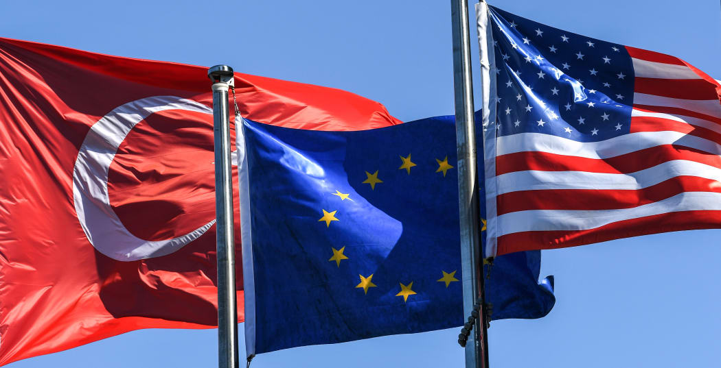Turkish flag, European Union's flag and US flag float in the wind at the financial and business district Maslak in Istanbul.