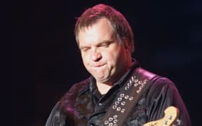 Singer Meatloaf playing the guitar.