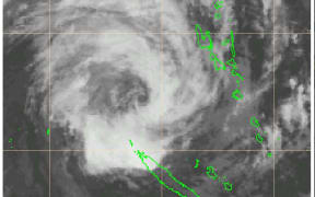 A satellite image of Cyclone Oma as it tracks away from Vanuatu and towards the north of New Caledonia (botttom green outline).