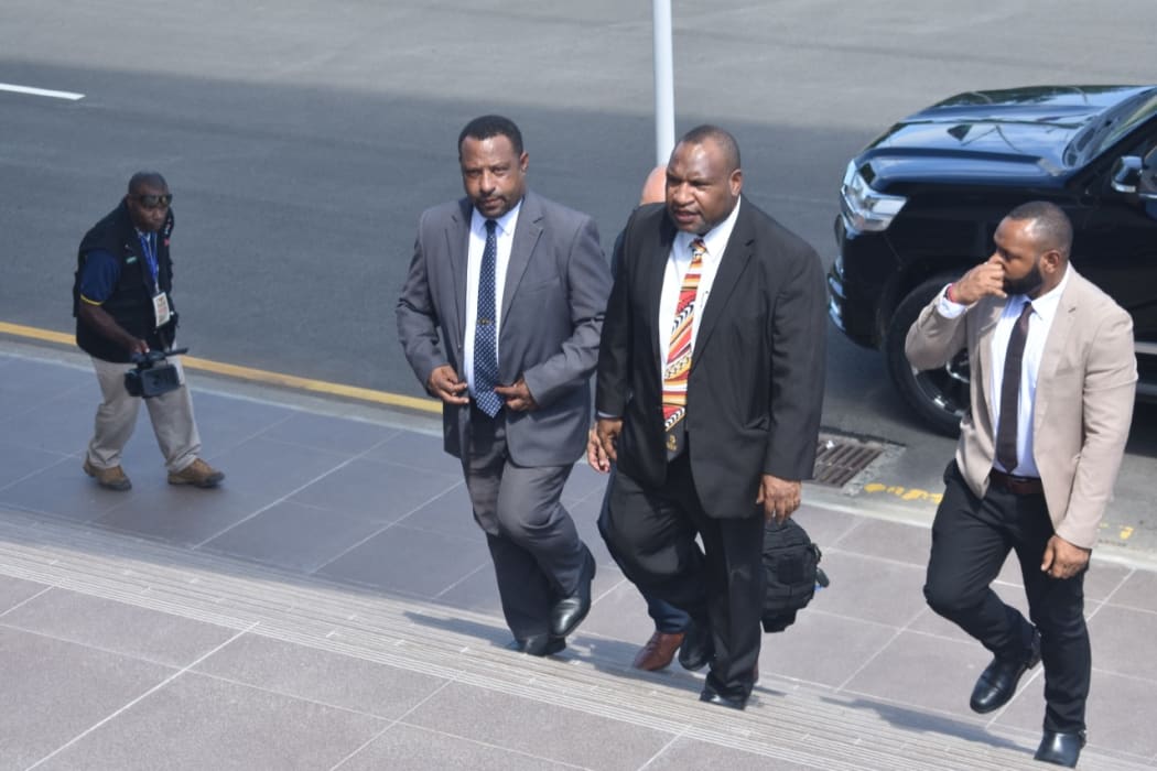 James Marape (centre in black suit) walks back to parliament after being sworn in as prime minister of Papua New Guinea, 30 May 2019.