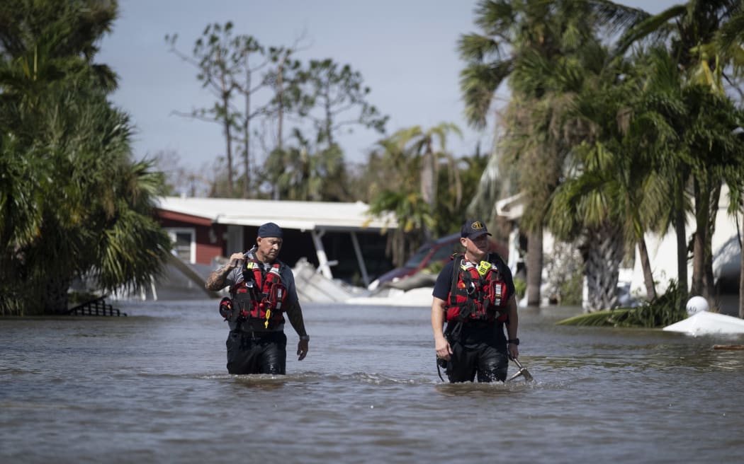 Arama ve kurtarma personeli, Florida, Fort Myers'daki Ian Kasırgası sonrasında hayatta kalanları ararken, sular altında kalan bir mahallede geziniyor.