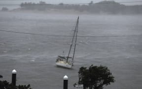 Strong winds and waves pound a boat in Cooktown on Friday.