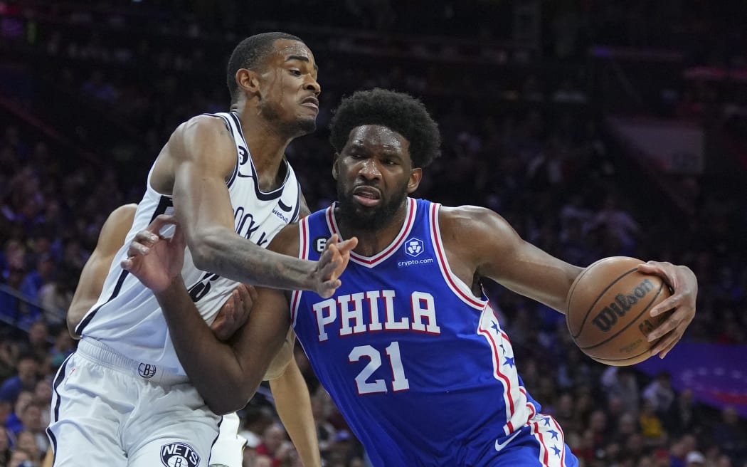 Joel Embiid of the Philadelphia 76ers drives to the basket against Nic Claxton of the Brooklyn Nets.