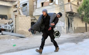 A Syrian civil defence volunteer, known as the White Helmets, carried an injured man following air strike on Aleppo's rebel-held neighbourhood of Bab al-Nayrab.