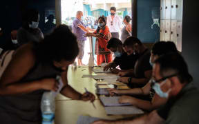 People prepare to casts their ballot for the referendum on independence at a polling station of the City Hall in Noumea, on the French South Pacific territory of New Caledonia on December 12, 2021.