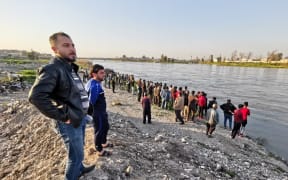 MOSUL, IRAQ - MARCH 21: Citizens follow the search and rescue operations around the site after a ferryboat sank in Iraqs Tigris River, leaving at least 55 people dead and more than 100 others injured, in Mosul, Iraq. The ferryboat was reportedly carrying 170 passengers when it sank near Mosul.
