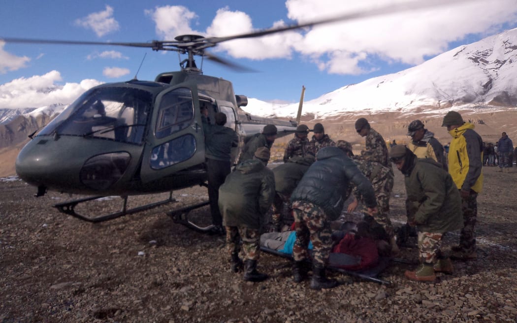 An injured survivor is assisted by army personel into a Nepalese Army helicopter in Manang District, along the Annapurna Circuit Trek.