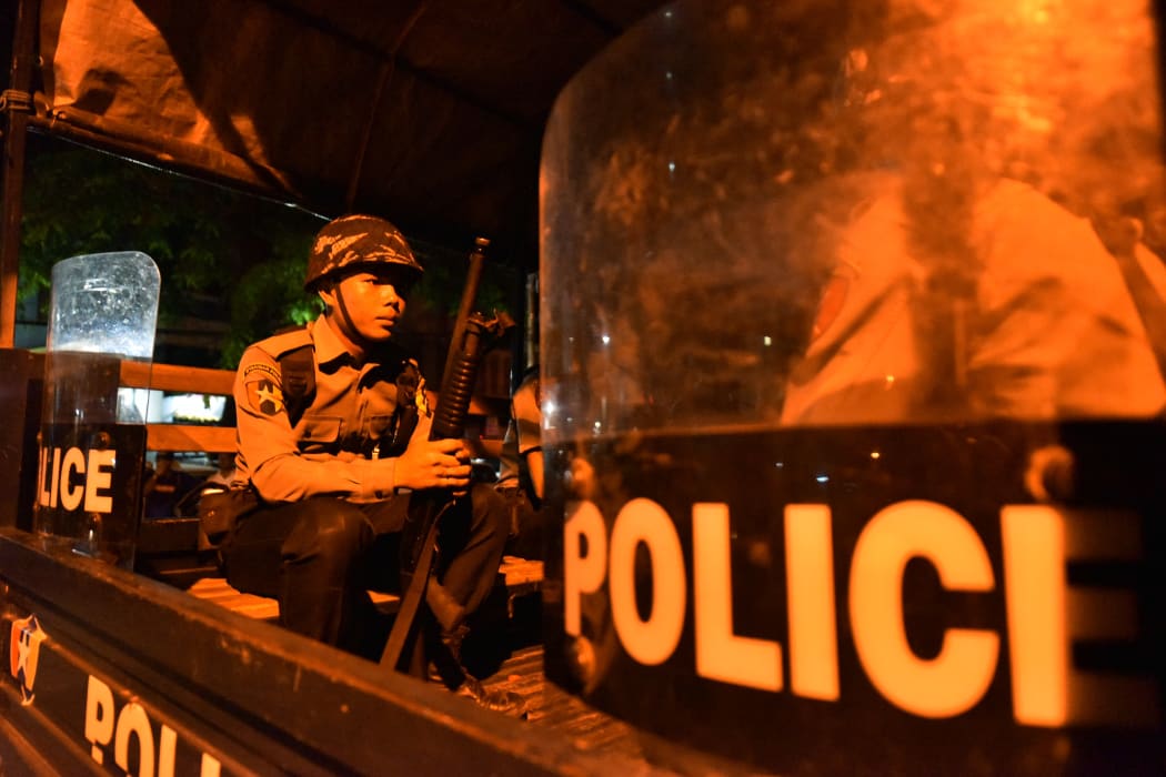 A Myanmar riot policemen sits in a truck on a street in Yangon's Mingalar Taung Nyunt township early on May 10, 2017, after scuffles broke out between Buddhist nationalists and Muslims.