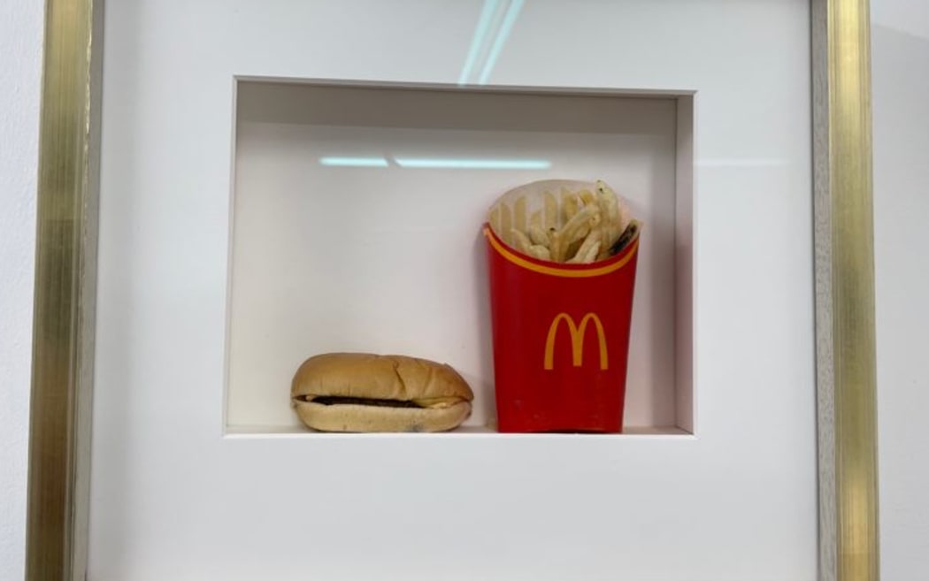 A gold frame with a burger and fries inside.