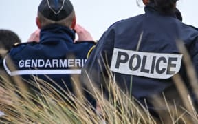 A French gendarme and police officer observe the beach of Oye-Plage, near Calais, northern France, as part of a monitoring mission of beaches from which migrants attempt to cross the English Channel to reach the United Kingdom, on Brexit Day, January 31, 2020.