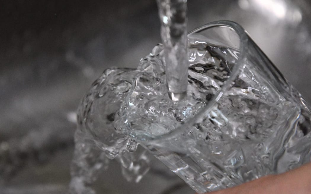 A glass of water being poured.