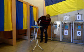 A member of a district electoral commission prepares booths at a polling station in Kiev.