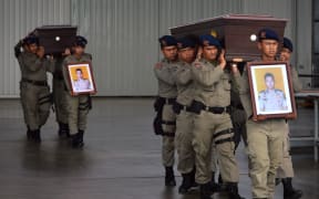 Indonesian police carry coffins with the bodies of the slain policemen found dead after patrolling the Grasberg complex in Papua province.