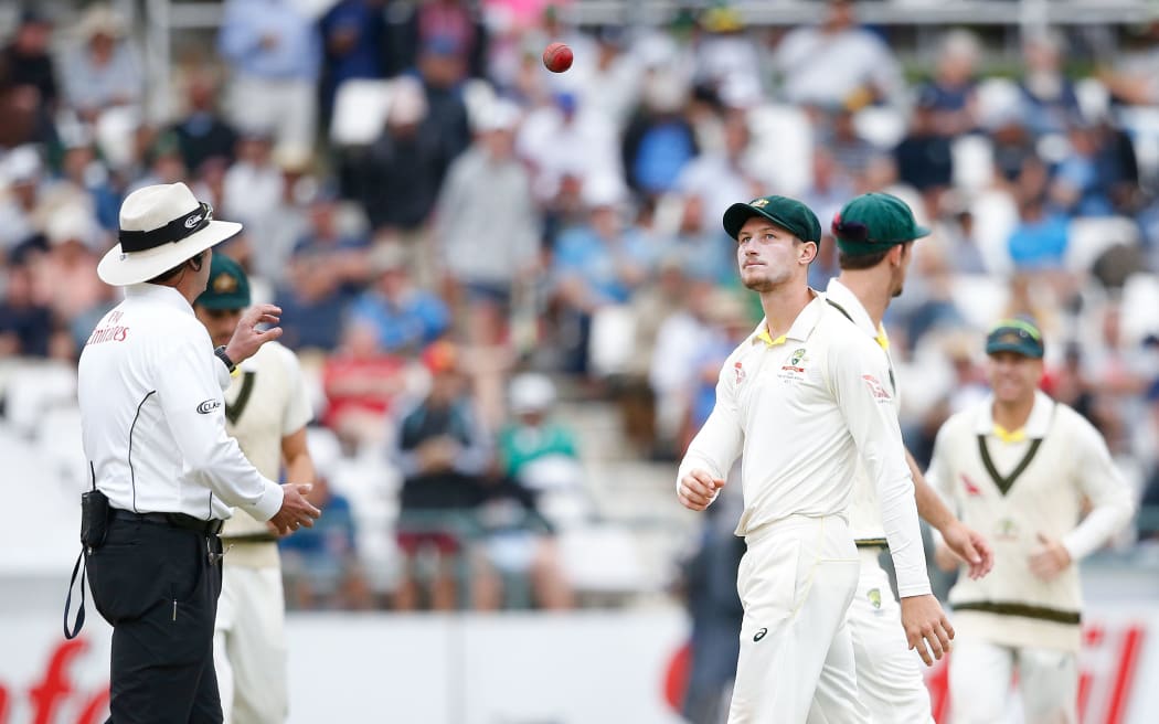 Australian fielder Cameron Bancroft (R) throws the ball to Umpire Richard Illingworth (L) during the third day of the third Test cricket match between South Africa and Australia.
