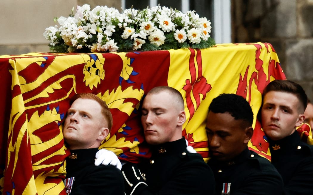A pallbearer carries the coffin of the late Queen Elizabeth II, covered in the Royal Standard of Scotland, at the Palace of Holyroodhouse, Edinburgh, 11 September 2022.