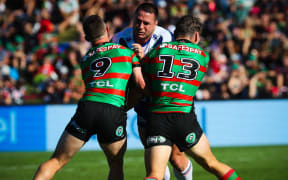 Warriors forward Lachlan Burr charges into the tackle of two Rabbitohs defenders.