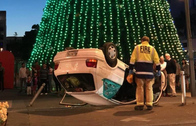 An overturned car under a Christmas tree in central Hamilton.