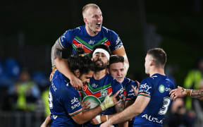 Warriors player celebrate with Shaun Johnson after he kicked the winning field goal against the Canberra Raiders at Mt Smart Stadium.
