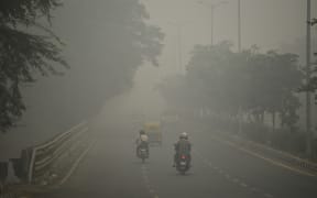 Motorists drive along a road under heavy smog conditions, in New Delhi on 3 November, 2019.