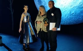 Sophie Petley models this year's winning design, 'Diva's Dreamscape'. She stands with Dame Suzie Moncrieff and supreme award winner, Peter Wakeman.