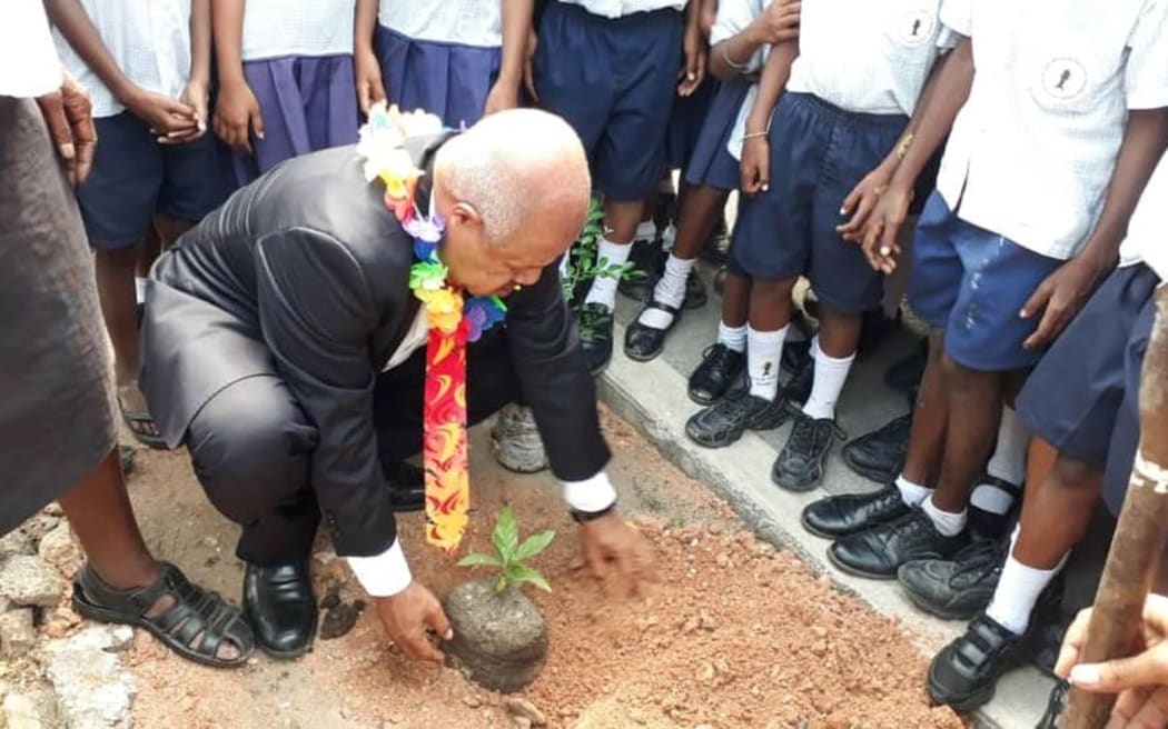 The governor of Papua New Guinea's National Capital District, Powes Parkop, plants a tree at the start of an initiative to plant one million trees in Port Moresby.