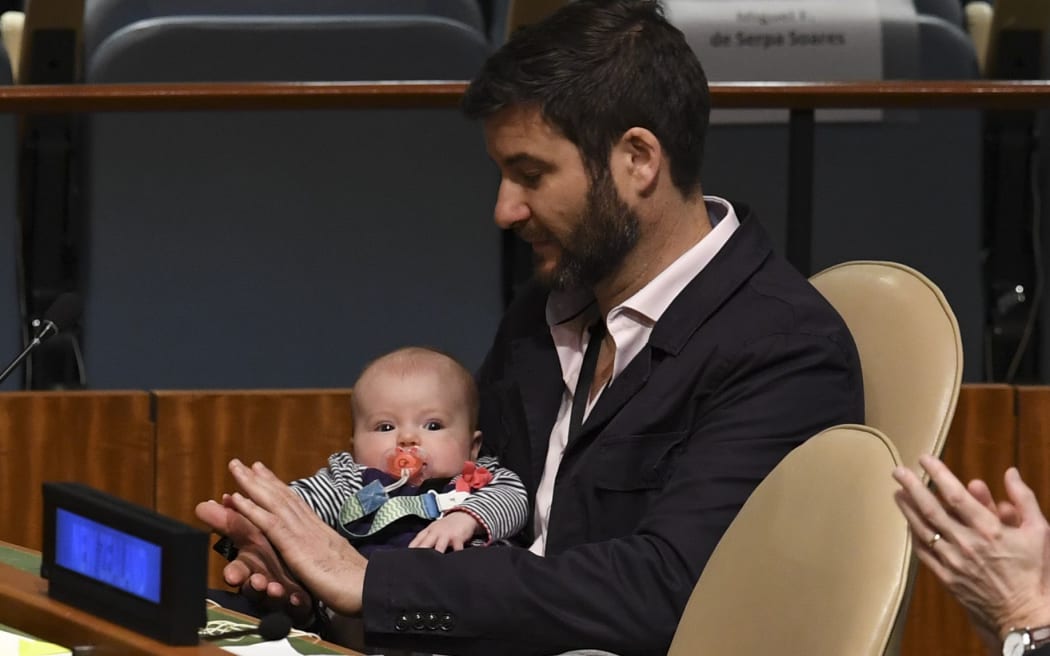 Clarke Gayford with his daughter Neve Te Aroha Ardern Gayford, as Prime Minister Jacinda Ardern speaks during the Nelson Mandela Peace Summit at the UN.