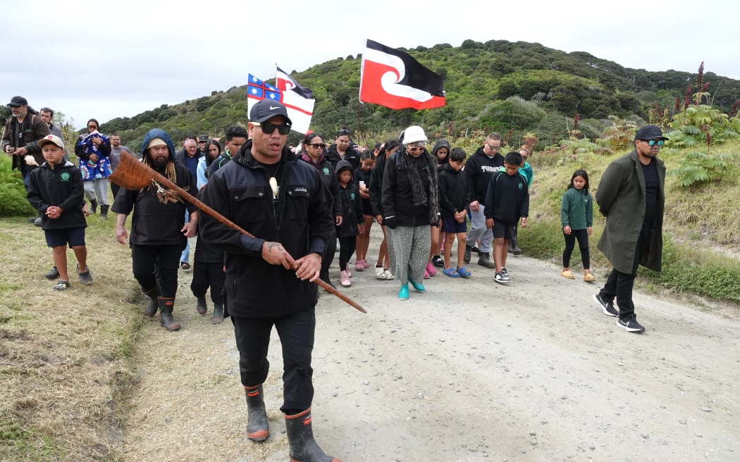 Pene Tawhara leads a hīkoi at Whatuwhiwhi, on the Karikari Peninsula, sparked by what hapū members say is desecration of wāhi tapu.