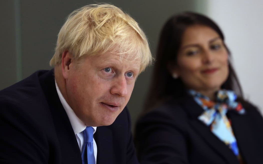 Britain's Prime Minister Boris Johnson (L), accompanied by Britain's Home Secretary Priti Patel, speaks at the first meeting of the National Policing Board at the Home Office in London, on July 31, 2019. (Photo by Kirsty Wigglesworth / POOL / AFP)