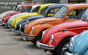 Vintage Volkswagen Beetle cars are parked in a row during a rally held as part of the 23rd anniversary of "World Wide VW Beetle Day".