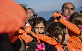 Migrants and refugees arrive on the Greek island of Lesbos after crossing the Aegean Sea from Turkey on 18 November 2015.