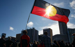 An Aboriginal flag is held aloft during a Black Lives Matter protest to express solidarity with US protesters and demand an end to Aboriginal deaths in custody, in Perth on June 13, 2020. (Photo by Trevor Collens / AFP)