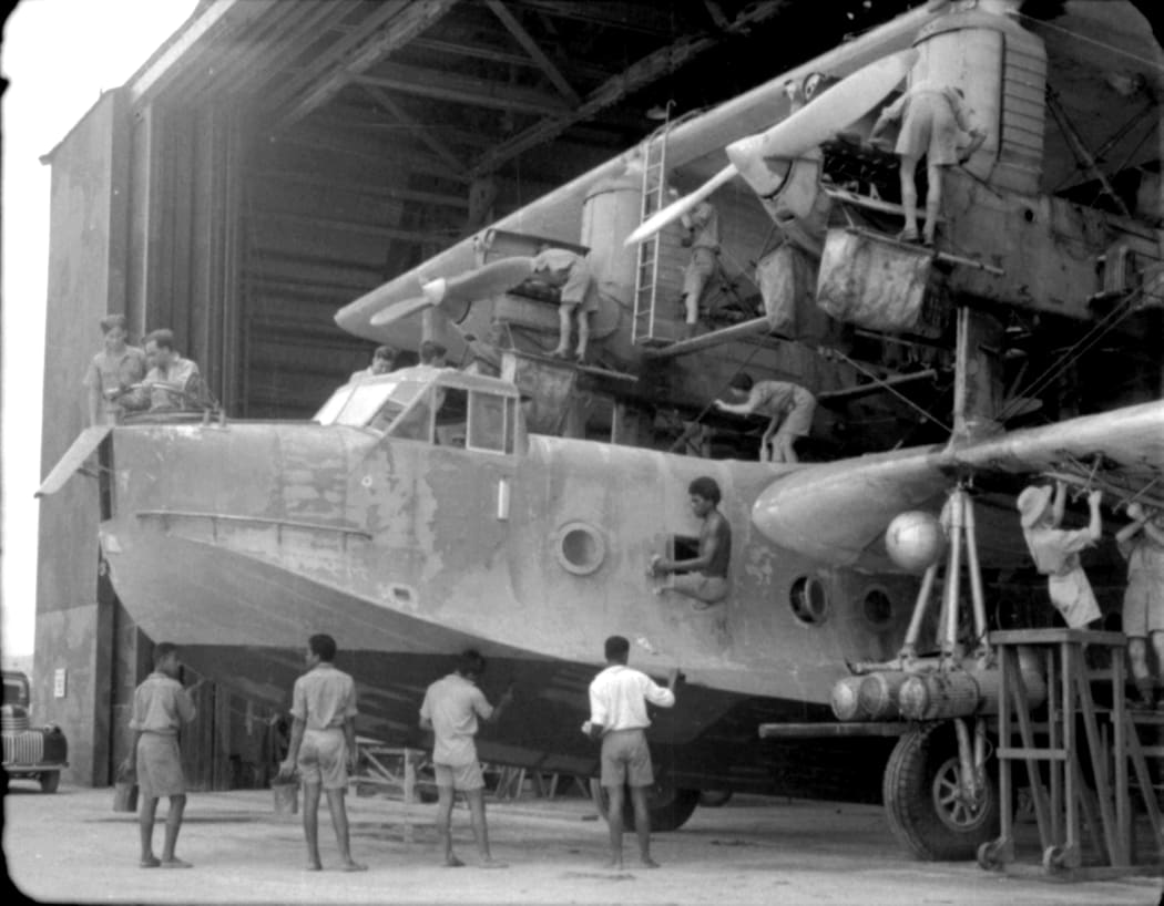 RNZAF ground crew work on Singapore flying boat in Laucala Bay hanger, Fiji.