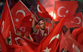 A man waves a Turkish flags during a meeting in support of the Turkish president on Taksim Square on 19 July.