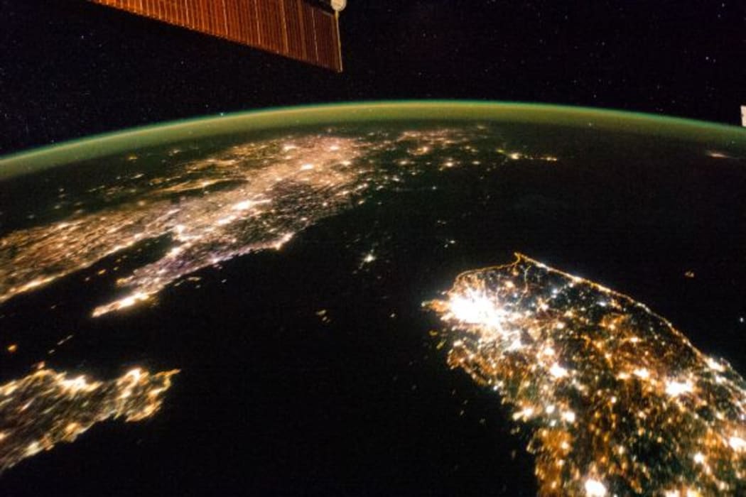 The Korean Peninsula at night. North Korea almost completely dark, the bright spot is Pyongyang.
