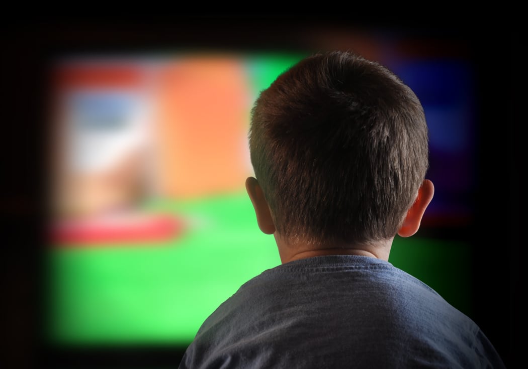 A close-up of a child watching television