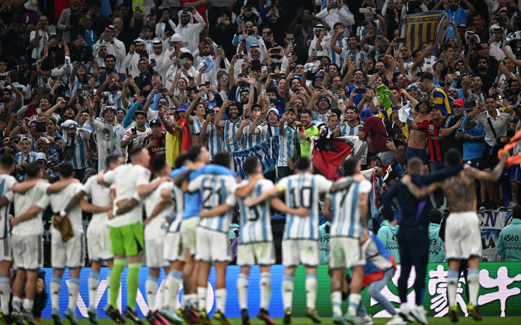 Argentina players celebrate with their supporters after they won the Qatar 2022 World Cup football semi-final match between Argentina and Croatia at Lusail Stadium in Lusail, north of Doha on 13 December, 2022.