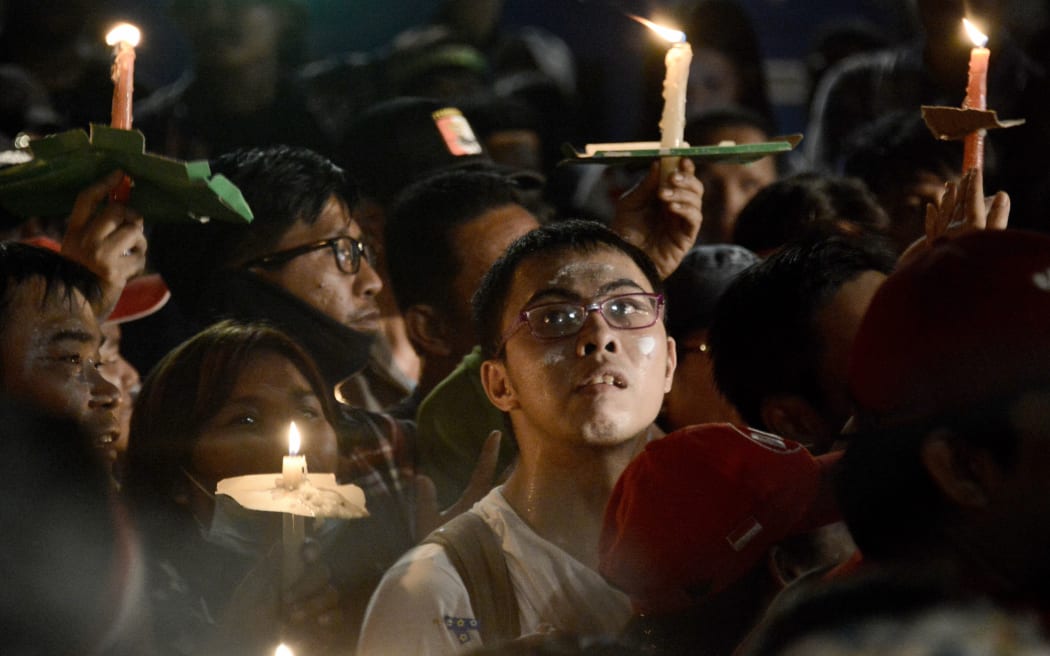 Protesters hold up lighted candles during a gathering outside the Indonesian High Court building in Jakarta to demand the release of Basuki Tjahaja Purnama.
