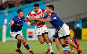 Japan's fly-half Yu Tamura (C) is tackled during the Japan 2019 Rugby World Cup Pool A match against Russia.