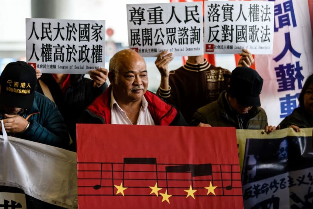 A Hong Kong pro-democracy activist holds a placard  during a protest outside the Legislative Council  in Hong Kong on January 23, 2019, against a proposed law to punish anyone who disrespects the anthem with up to three years in jail.