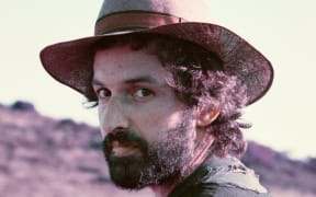 Joachim Cooder poses in the desert wearing a hat