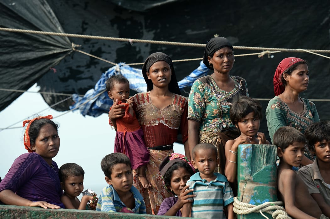 Rohingya migrants stand and sit on a boat drifting in Thai waters off the southern island of Koh Lipe in the Andaman sea on May 14, 2015