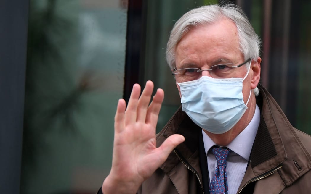 EU chief negotiator Michel Barnier wearing a protective face covering to combat the spread of the coronavirus, waves to members of the media as he leaves a conference centre as negotiations on a trade deal between the EU and the UK continue in London on November 28, 2020.