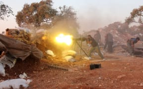 A rebel fighter fires heavy artillery during clashes with government forces and pro-regime shabiha militiamen in the outskirts of Syria's northwestern Idlib province on September 18, 2015.