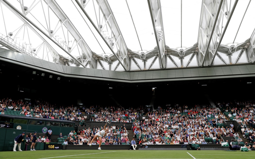 Australia's Ashleigh Barty serves against Spain's Carla Suarez Navarro during their women's singles first round match under the closed roof on Centre Court on the second day of the 2021 Wimbledon Championships at The All England Tennis Club in Wimbledon, southwest London, on June 29, 2021. (Photo by Adrian DENNIS / AFP) / RESTRICTED TO EDITORIAL USE
