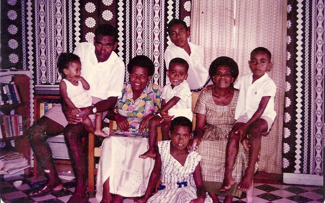 A young Dr Api sitting on the arm of sofa to the left of his paternal grandmother Timaleti Tausere in Suva. His parents Wapole and Makelesi Talematoga are on the left, his sister Laitipa Navara is sitting on his dad's lap and his brother Josateki Talemaitoga is in the middle next to his mum. At the back is his Dad's youngest brother Kaminieli and sitting on the ground at the front is cousin Timaleti.