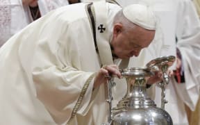 Pope Francis blows inside an amphora containing holy oil during a Chrism Mass inside St. Peter's Basilica, at the Vatican, Thursday, April 18, 2019.