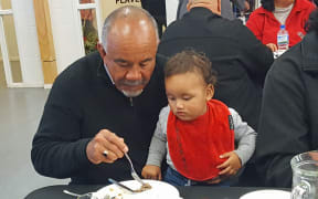 Mr Flavell with a mokopuna at the Māori Party's election night gathering at Waiteti Marae