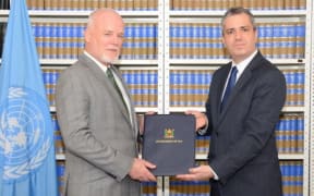 Fiji's Permanent Representative to the United Nations, Peter Thomson, receives the instruments of ratification for the UN Convention Against Torture at the UN